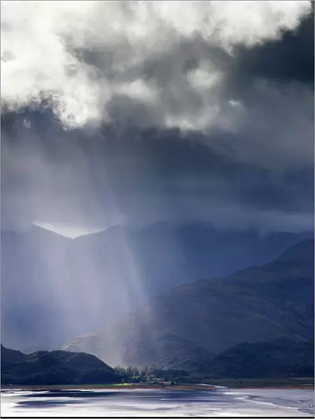 View from Carr Brae towards head of Loch Duich and Five Sisters of Kintail with sunlight bursting through sky, Highlands, Scotland, United
