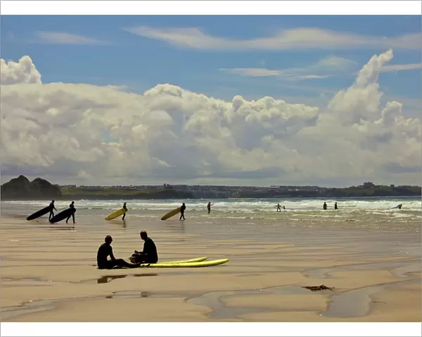Surfers with boards on Perranporth beach, Cornwall, England