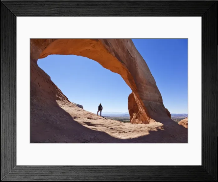 Framed Print : Lone tourist hiker at Wilson Arch, near Moab, Utah, United States of America, North America Framed Print : Lone tourist hiker at Wilson Arch, near Moab, Utah, United States of America, North America
