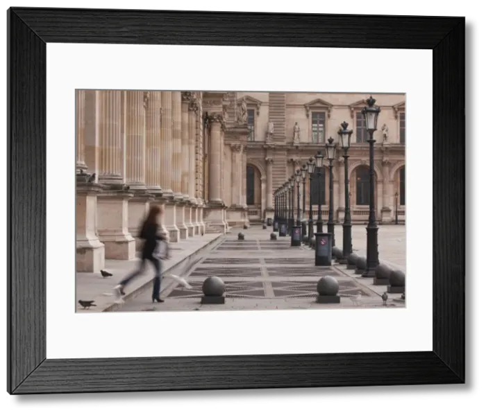Framed Print : A woman walks through the Louvre Museum in Paris, France, Europe Framed Print : A woman walks through the Louvre Museum in Paris, France, Europe