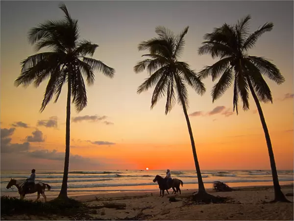 Horse riders at sunset, Playa Guiones surfing beach, Nosara, Nicoya Peninsula, Guanacaste Province, Costa Rica, Central America