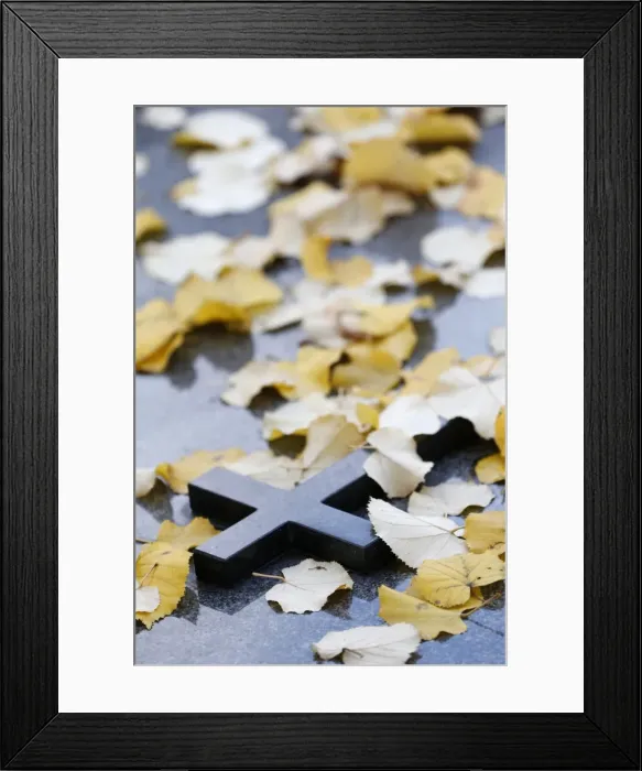 Framed Print : Cross on tombstone under dead leaves, France, Europe Framed Print : Cross on tombstone under dead leaves, France, Europe