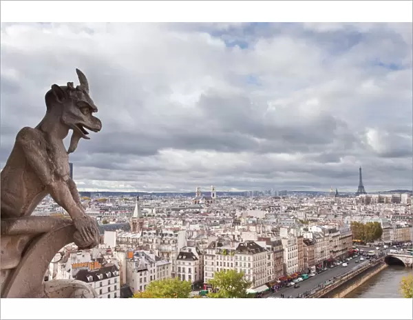 A gargoyle on Notre Dame de Paris cathedral keeping a watchful eye over the city below, Paris, France, Europe