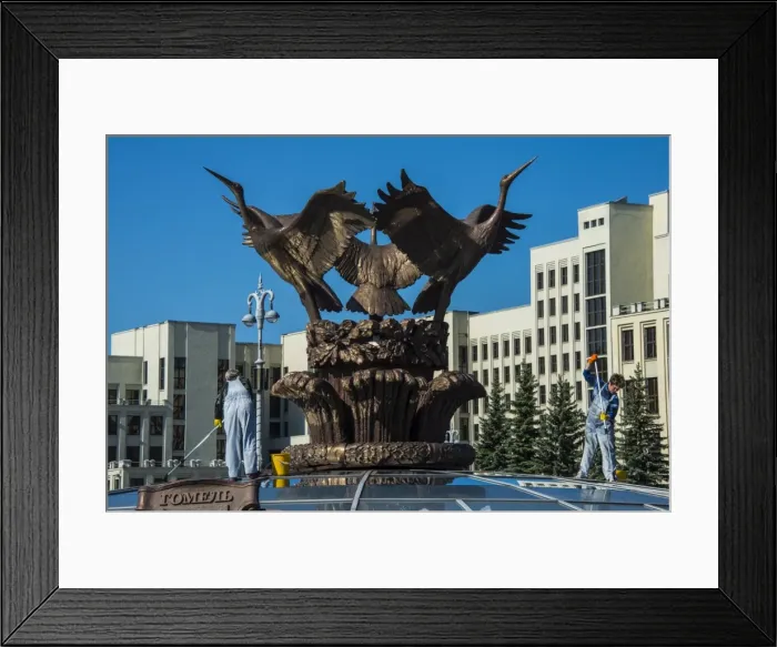 Framed Print : Woman cleaning a giant bird statue on top of a glass cupola on Nezalezhnasti Independence square, Minsk, Belarus, Europe
