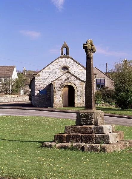 14th century village cross in front of the church of St. Hugh, Foolow, Derbyshire