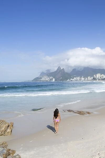 A 20-25 year old young Brazilian woman on Ipanema Beach with the Morro Dois Irmaos
