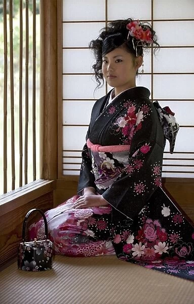 A 20-year old Japanese girl wearing spring furisode kimono with long sleeves to indicate her single social status