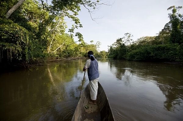 An Achuar man spear fishing on a tributary of the Amazon, Ecuador, South America