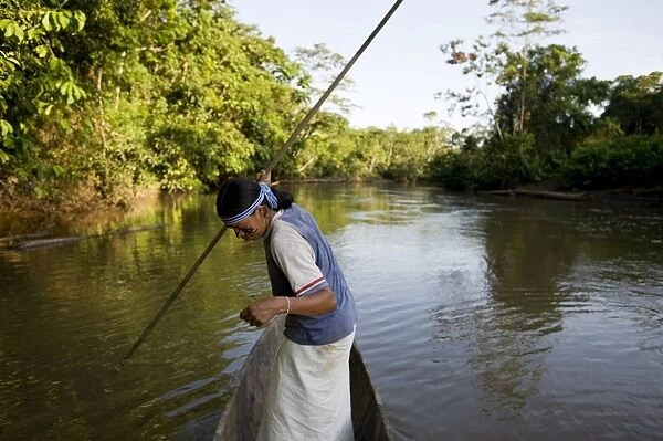 An Achuar man spear fishing on a tributary of the Amazon, Ecuador, South America