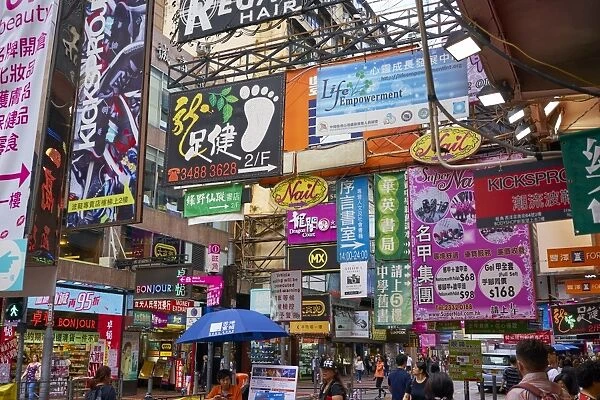 Advertising signs on a busy street in the popular shopping area of Mong Kok (Mongkok)