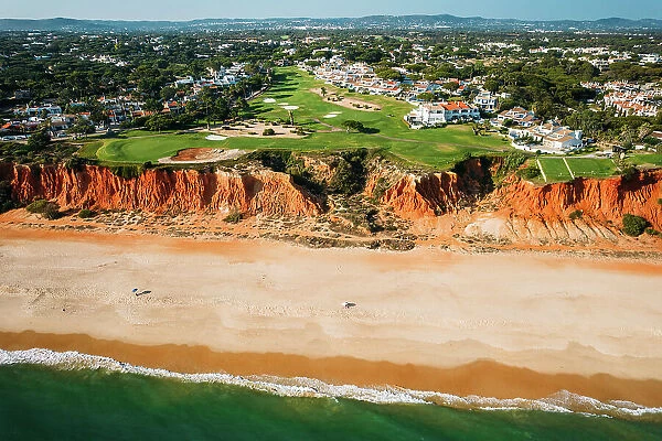 Aerial drone view of Praia de Vale do Lobo with magnificent golf courses overlooking the ocean in Algarve, Portugal, Europe