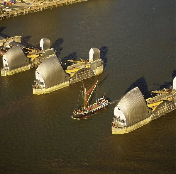 Aerial image of Thames sailing barge and Thames Flood Barrier across the River Thames