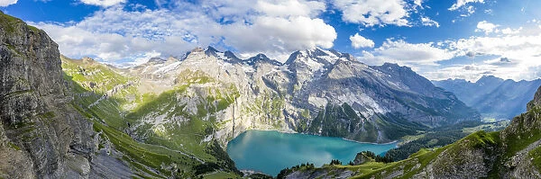 Aerial panoramic of Oeschinensee lake surrounded by woods in summer, Bernese Oberland