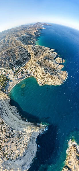 Aerial panoramic view of cliffs surrounding the beach of Matala seaside town, Crete