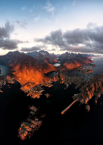 Aerial panoramic view of the coastal village of Tind framed by mountains at sunset, Lofoten Islands, Nordland, Norway, Scandinavia, Europe