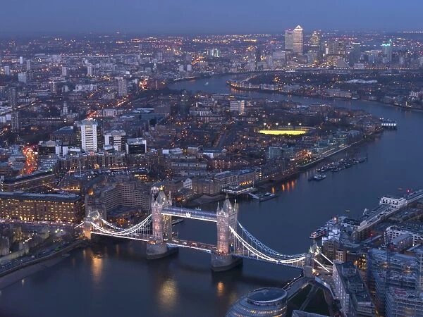 Aerial photo showing Tower Bridge, River Thames and Canary Wharf at dusk, London, England, United Kingdom, Europe