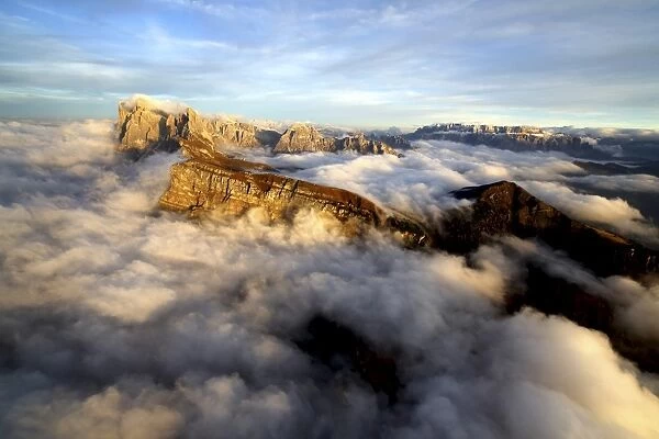 Aerial shot from Seceda of Odle surrounded by clouds at sunset in the Dolomites, Val Funes