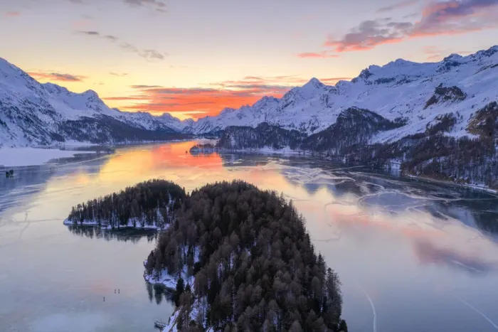 Framed Print : Aerial view of burning sky at sunset on frozen Lake Sils and snow capped mountains