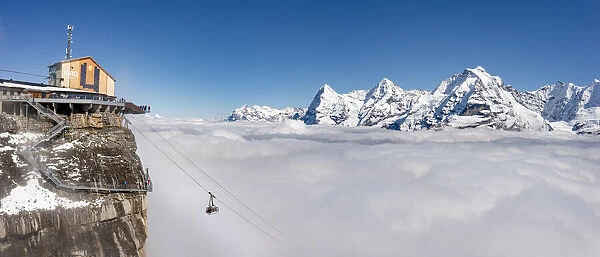 Aerial view of cable car in fog with Eiger, Monch, Jungfrau peaks in the background