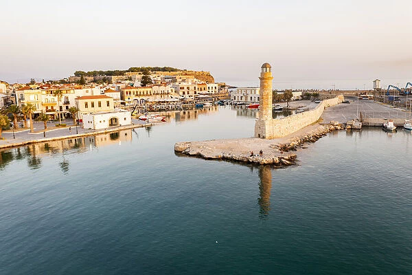 Aerial view of the calm sea at dawn surrounding the old Venetian port and lighthouse, Rethymno, Crete island, Greek Islands, Greece, Europe