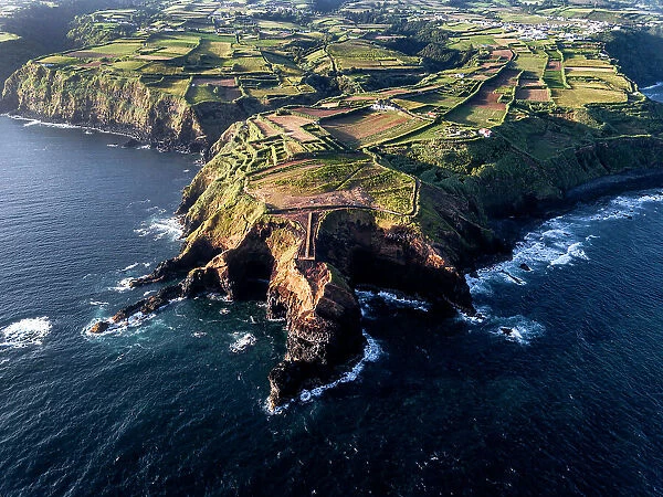 Aerial view of the coasts and cliffs of the island of Sao Miguel over the lighthouse of Farolim dos Fenais da Ajuda, Azores Islands, Portugal, Atlantic, Europe