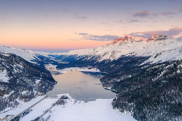 Aerial view of frozen Lake Silvaplana and Piz Corvatsch covered with snow at sunset