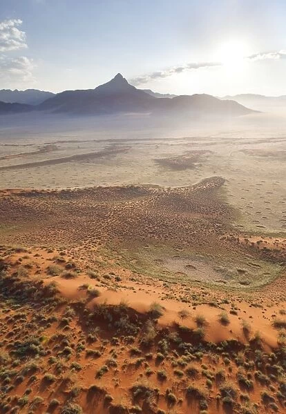 Aerial view from hot air balloon at dawn over magnificent desert landscape of sand dunes, mountains and Fairy Circles, Namib Rand game reserve Namib Naukluft Park, Namibia, Africa