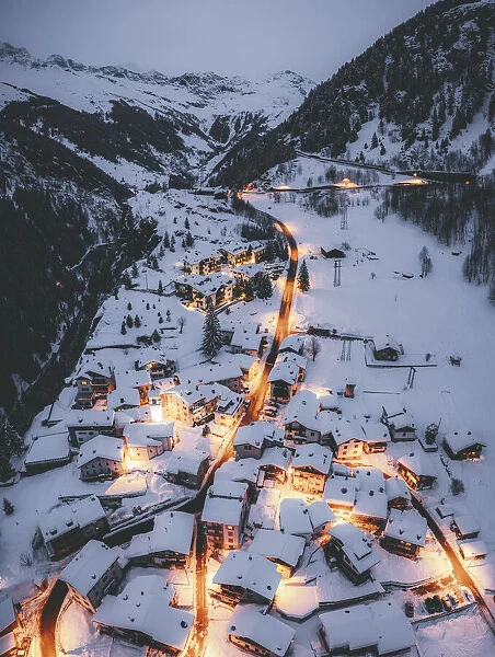 Aerial view of illuminated mountain huts covered with snow, Pianazzo, Madesimo