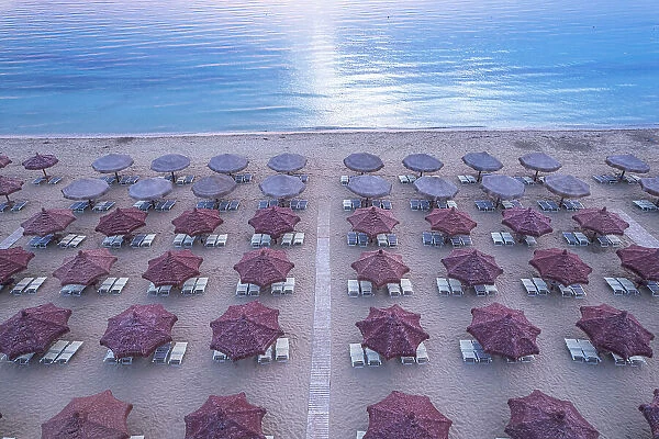 Aerial view of large group of tidy beach umbrellas facing the Mediterranean Sea, Italy, Europe