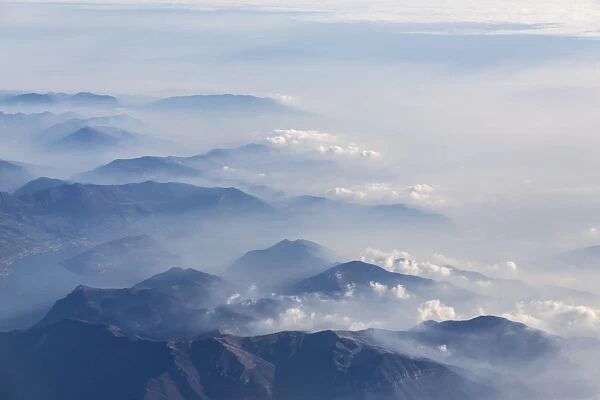 Aerial view of the profile of the mountain peaks surrounded by mist, Orobie Alps
