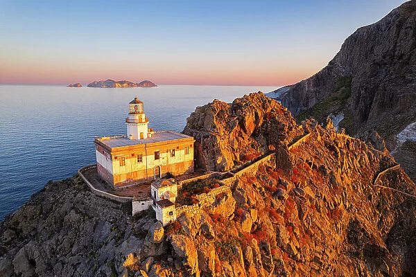 Aerial view of Punta della Guardia lighthouse on top of a cliff on the island of Ponza, lit from sunrise, Ponza island, Pontine islands, Mediterranean Sea, Latium, Lazio, Italy, Europe