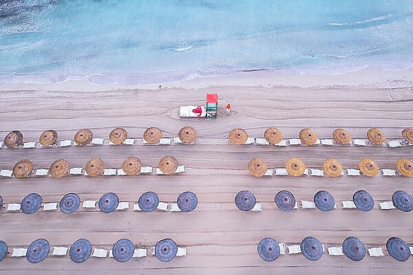 Aerial view of rows of beach umbrellas with a lifeguard tower on an sandy beach, Sicily island, Italy, Mediterranean Sea, Europe