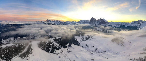 Aerial view of the snowcapped Sassolungo and Sassopiatto mountains at dawn, Seiser Alm