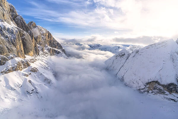 Aerial view of Valle Ombretta covered by clouds from Marmolada, Dolomites, Veneto, Italy