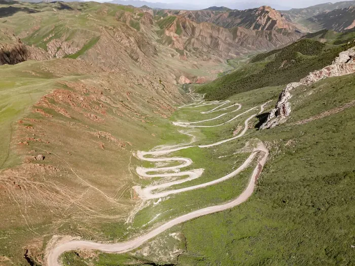 Framed Print : Aerial view of a winding mountain road curves, Kalmak Ashuu Pass, through lush greenery in Kyrgyzstan, Central Asia, Asia Framed Print : Aerial view of a winding mountain road curves, Kalmak Ashuu Pass, through lush greenery in Kyrgyzstan, Central Asia, Asia