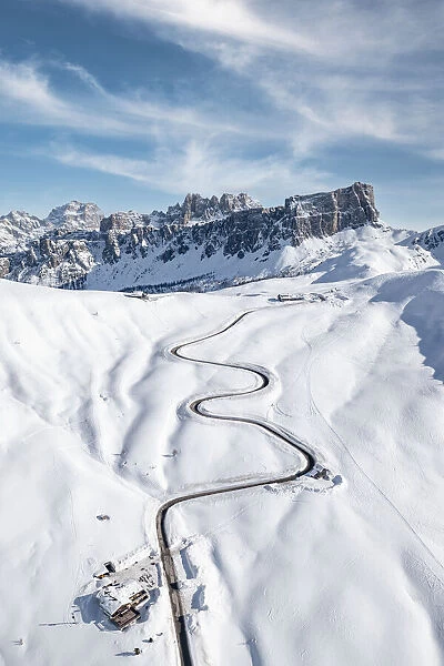 Aerial view of winding mountain road in the snow and Lastoi De Formin, Giau Pass