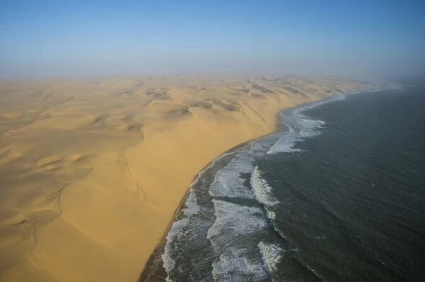 Aerials of sand dunes of the Namib Desert meeting the Atlantic Ocean, Namibia, Africa