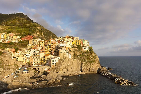 Afternoon sun and colourful buildings by sea in Manarola, Cinque Terre, UNESCO World Heritage Site