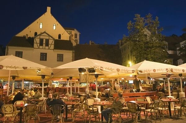 Al fresco dining at night in square of traditional buildings