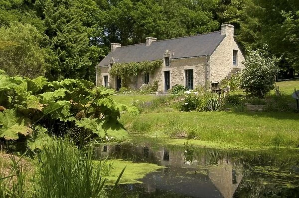 Ancient farm house and pond, granite walls and slate roof, Bubry village