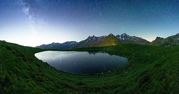 Andossi lake lit by glowing stars in the night sky, Madesimo, Valle Spluga, Valtellina, Lombardy, Italy, Europe