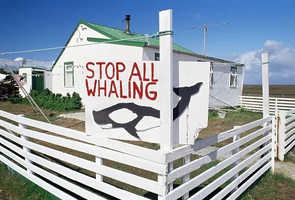 An anti-whaling sign in front of Falkland traditional wooden house, Sea Lion Islands