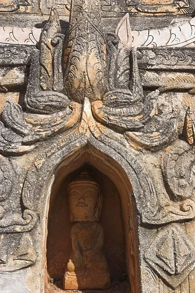 Antique Buddha image in niche below stupa, Kakku Buddhist Ruins, said to contain over two thousand brick and laterite stupas, legend holds that the first stupas were erected in the 12th century by Alaungsithu, King of Bagan (Pagan), Shan State, Myanmar