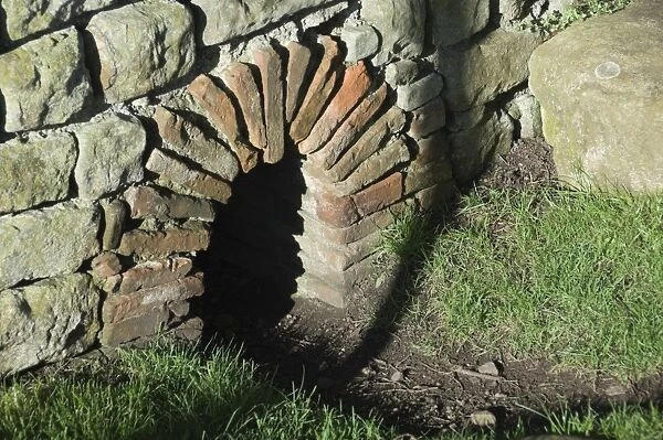 Architectural detail of a culvert exit approximately 30 cm high, under the wall of the AD 130 Cilurnum - Chesters Roman Fort, Chollerford, Northumbria National Park, England, United Kingdom, Europe