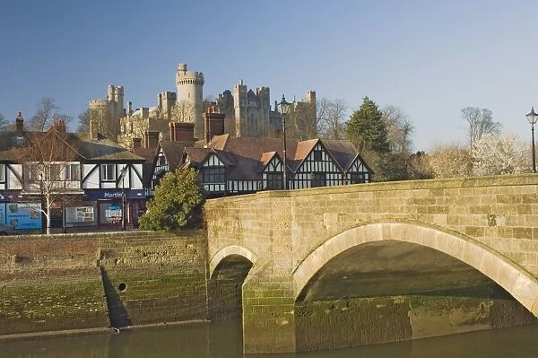 Arundel Castle from across tidal inlet with town bridge with half timbered town houses