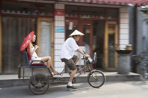 Asian woman (Chinese-Thai) riding in cycle rickshaw, Hutong District, Beijing