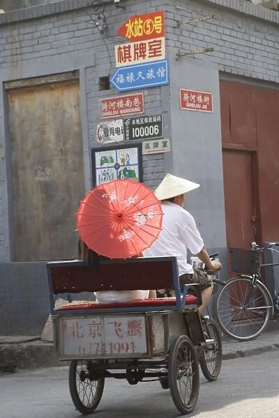 Asian woman riding in cycle rickshaw, Hutong District, Beijing, China, Asia