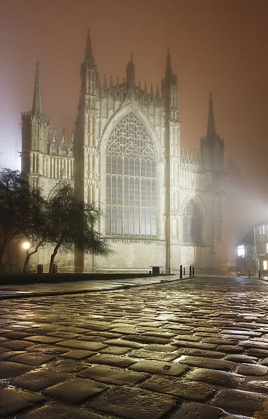 An atmospheric misty mid-winter view of York Minsters East window after dark, York, Yorkshire, England, United Kingdom, Europe
