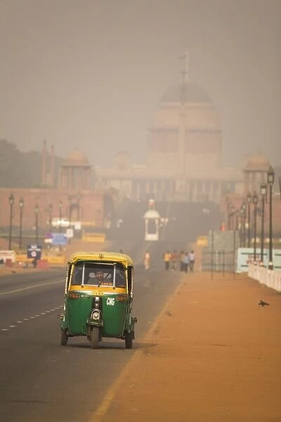 An auto rickshaw drives along the Rajpath, in front of the Rashtrapati Bhavan