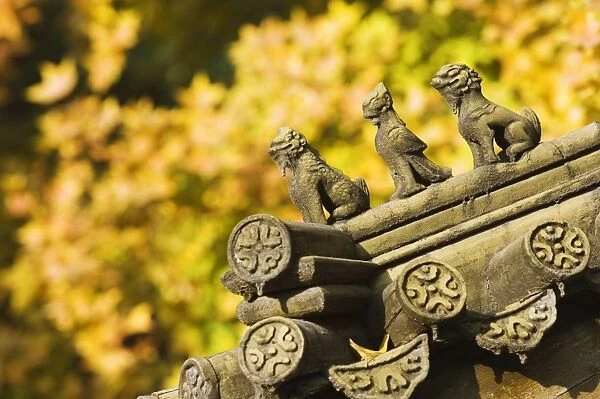 Autumn colours and ornamental Chinese style decorative figures on a pavilion in Ritan Park